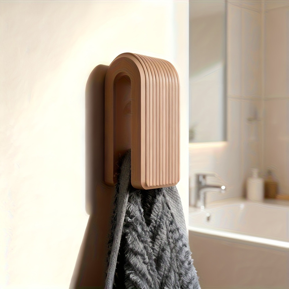 One brown ribbed holder shown with a grey towel against a light wall.